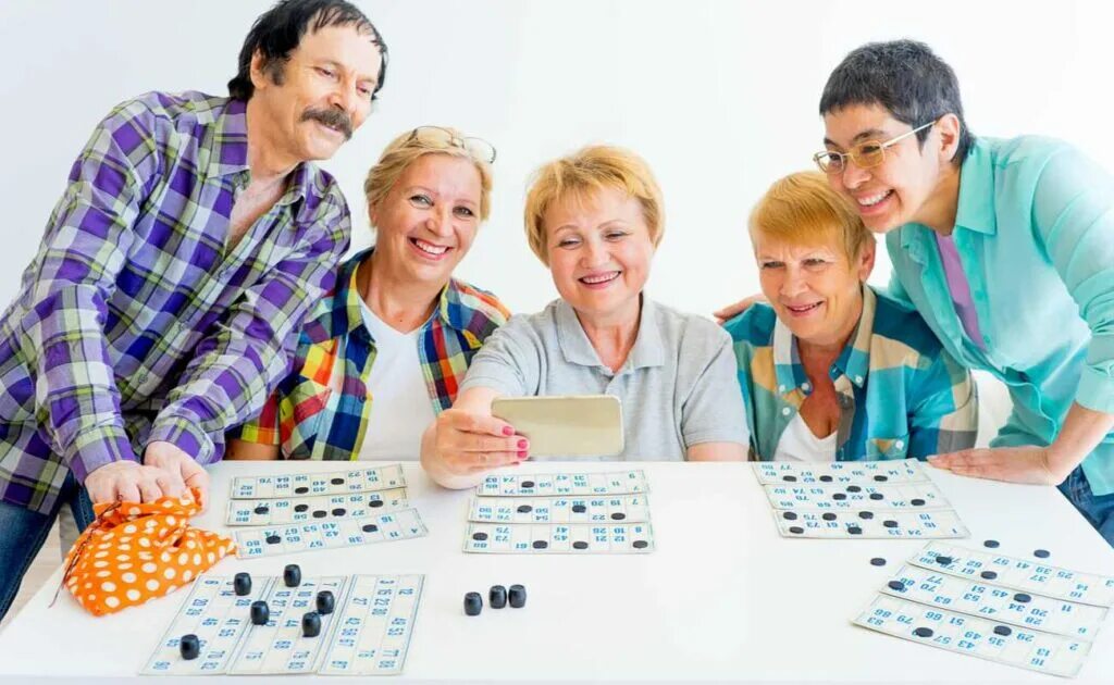 В старшие были люди. Пожилые люди играющие в настольные игры. Люди играют в Бинго. Настольные игры для Стариков. Пожилые люди играющие в Бинго.