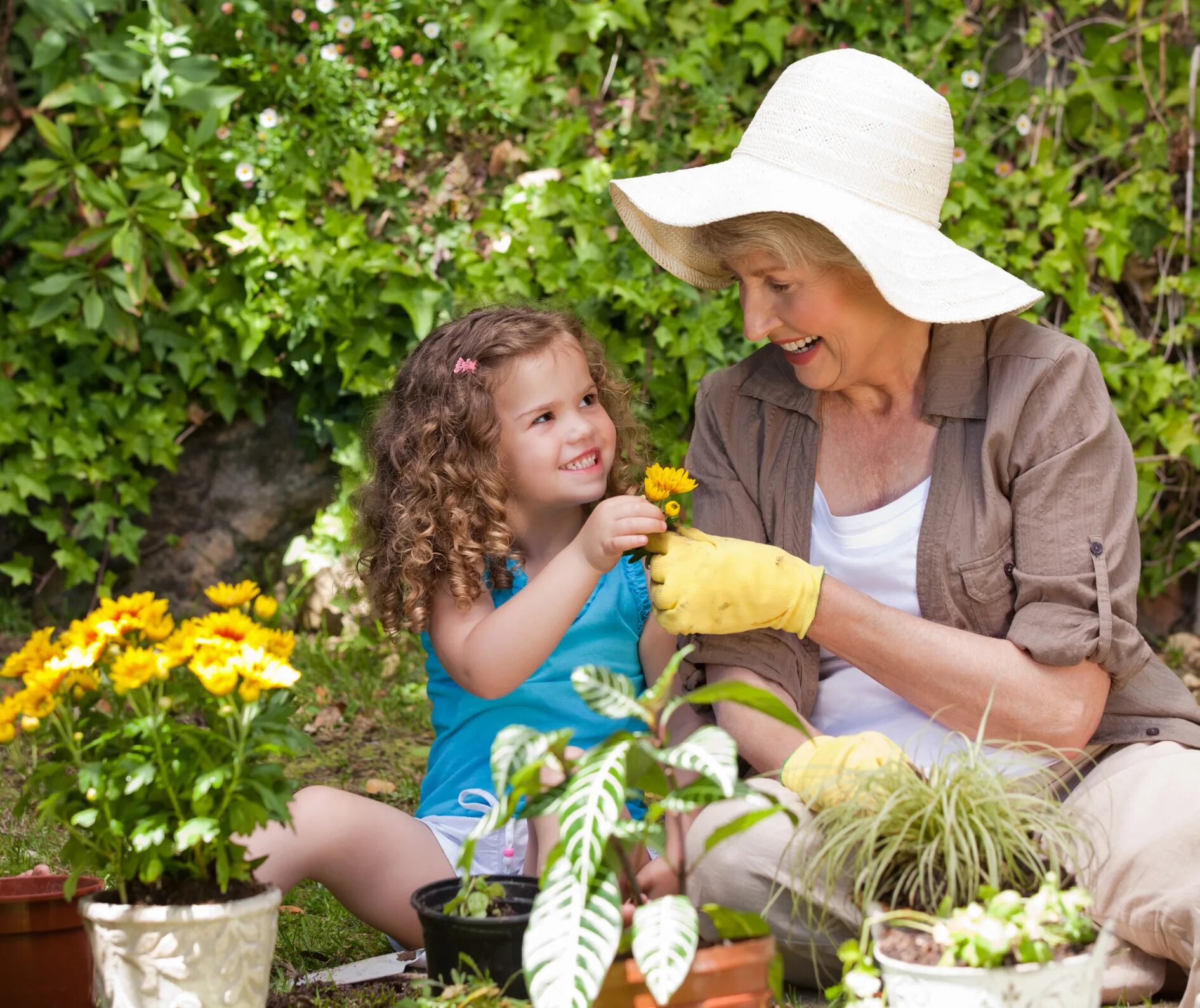 Семья в саду. Огород для детей. Бабушка и внучка в саду. Бабушка с внуками на даче. Заботиться о цветах
