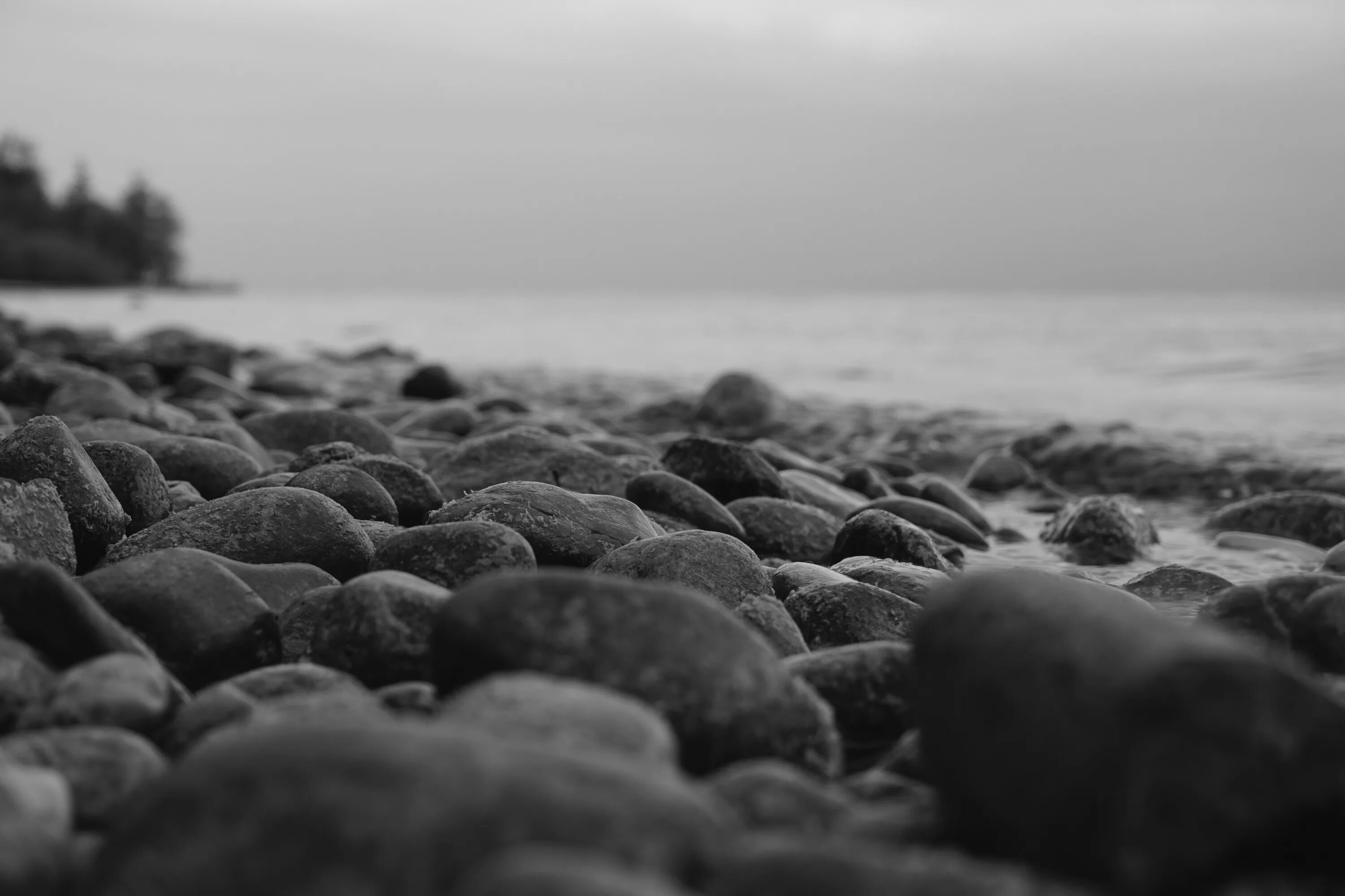 Игра черно белые камни на доске. Каменный пляж. Черно белый камень. Камни черного моря. Камни на пляже.