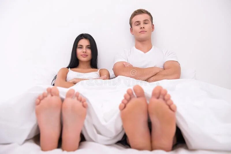 Couples feet. Мужчина у ног женщины. Ступни пары. Мужские ноги на кровати. Ноги семейной пары.