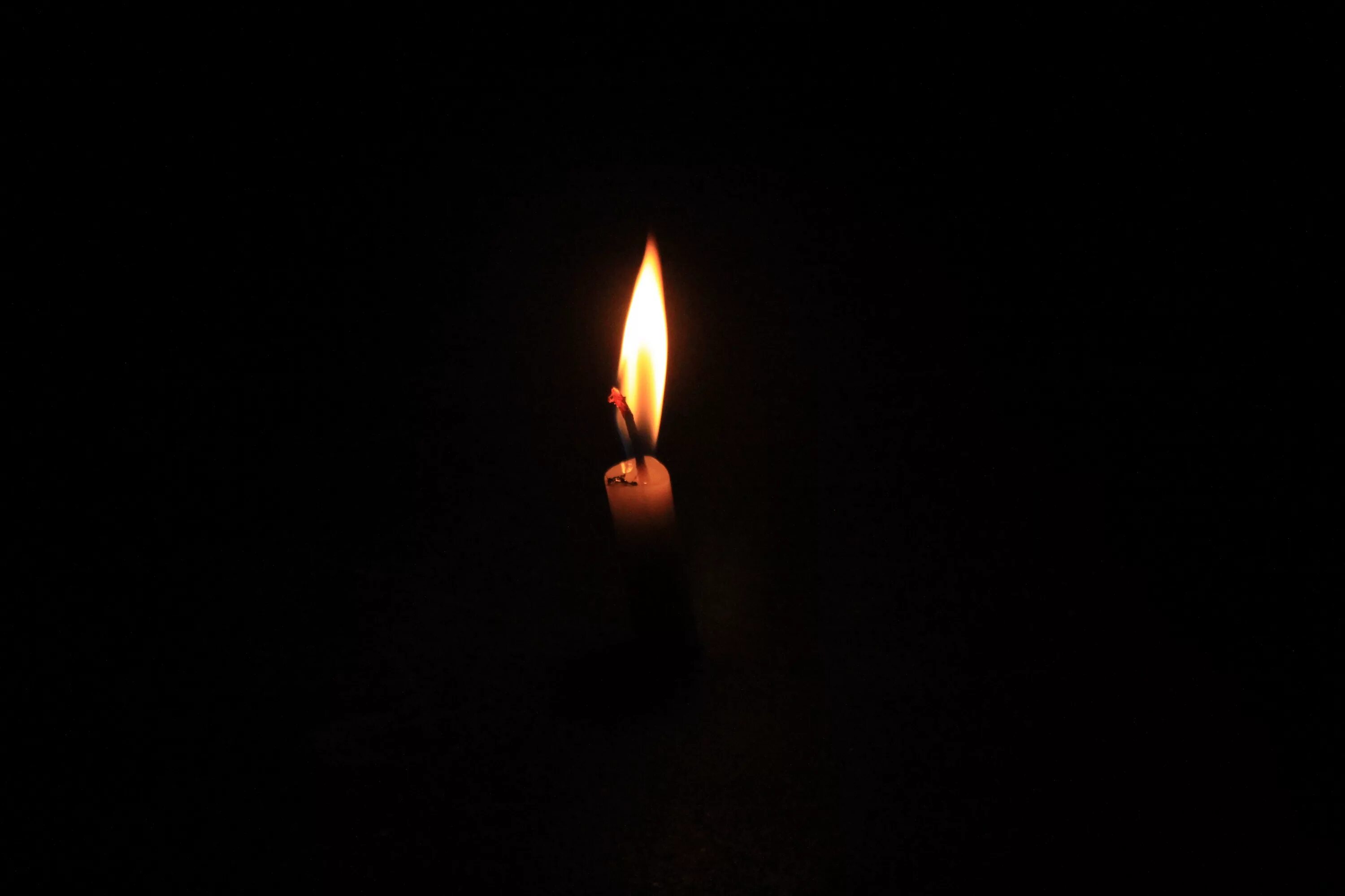 Свеча на темном фоне. Горящая свеча. Свеча скорби. Свеча в темноте. Горящая свеча 22.03 2024