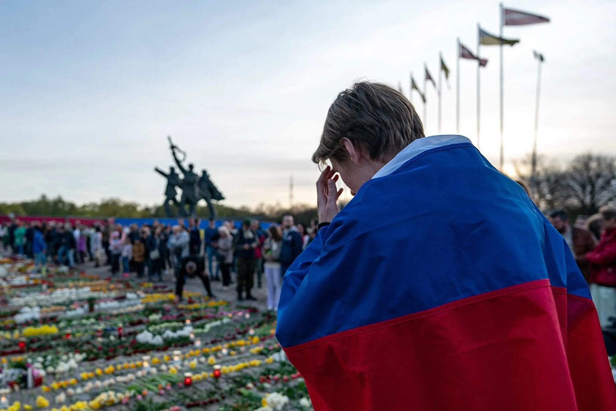 Люди с флагами России. Парень с русским флагом в Риге. Латвия день Победы. Мужчина с российским флагом.