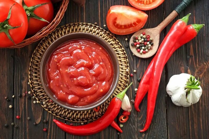 Приготовить домашнюю томатную пасту на зиму. Острая томатная паста. Томатная паста в тарелке. Кетчуп в тарелке. Кетчуп стоковое фото.