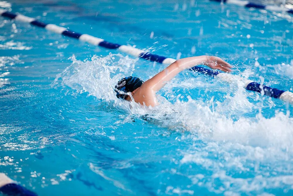 плавание в бассейне. плавание вид спорта. человек плывет в бассейне. пловец в бассейне. женщина плывет вперед.