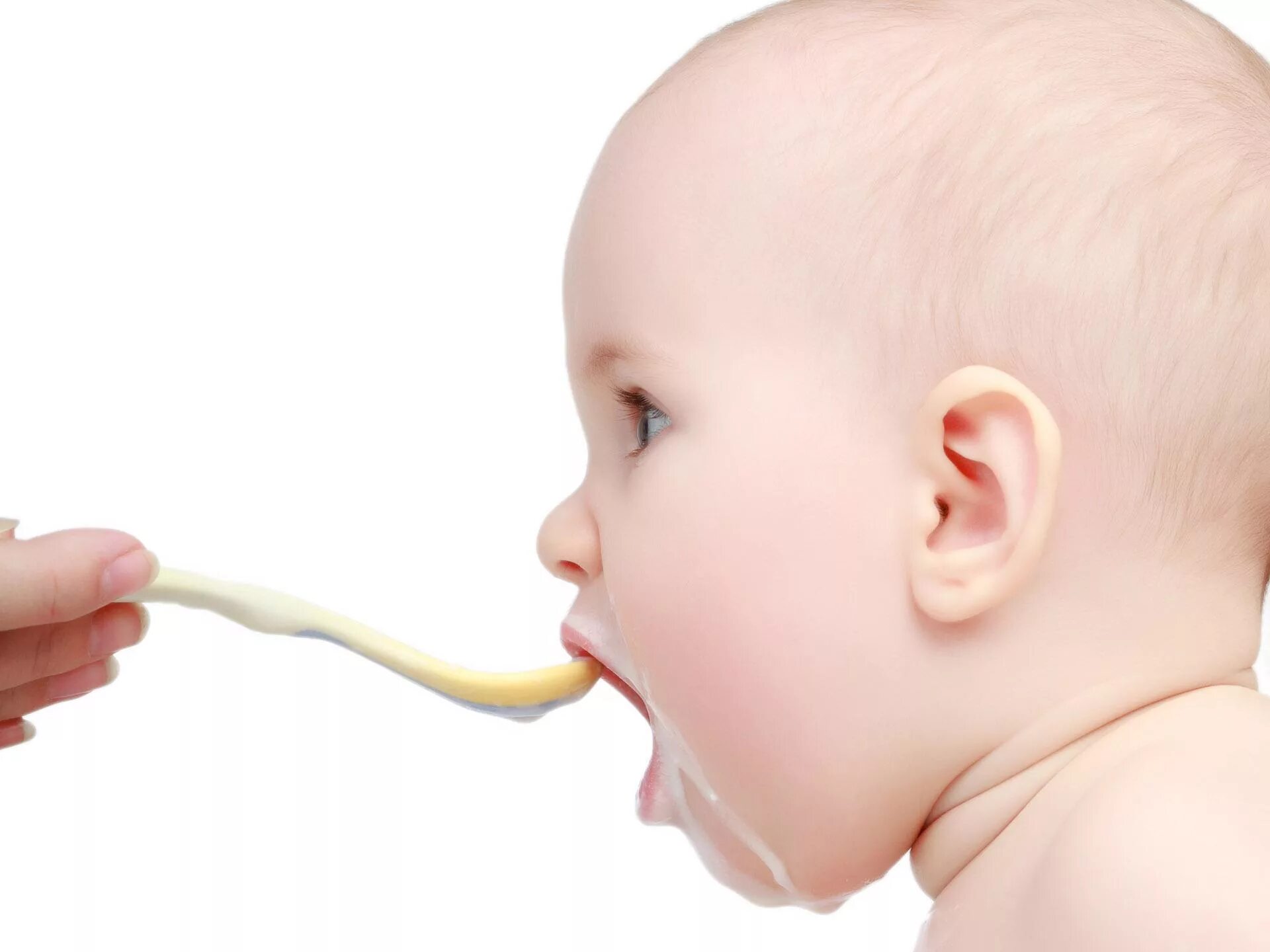 6 месяцев срыгивает. Малыш кушает. Первый прикорм малыша. Кормление ребенка с ложечки. Ребенок ест прикорм.