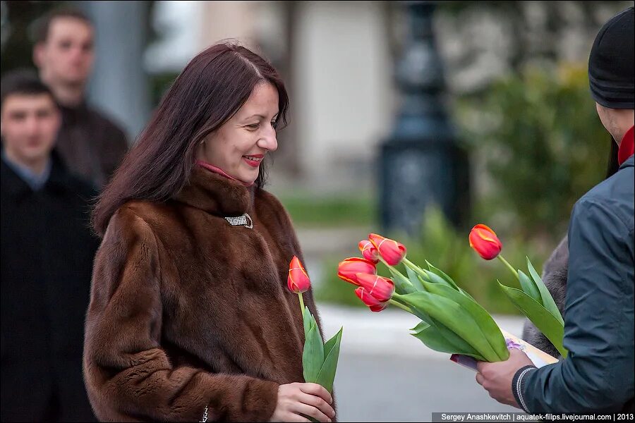 Фото с тюльпанами на улице. Дарит цветы. Женщина с тюльпанами.