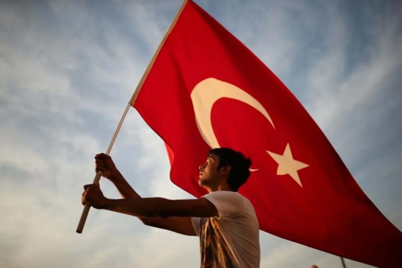 Что у турков означает. Человек с флагом. Человек с флажком. Человек с турецким флагом. Флаг Турции.