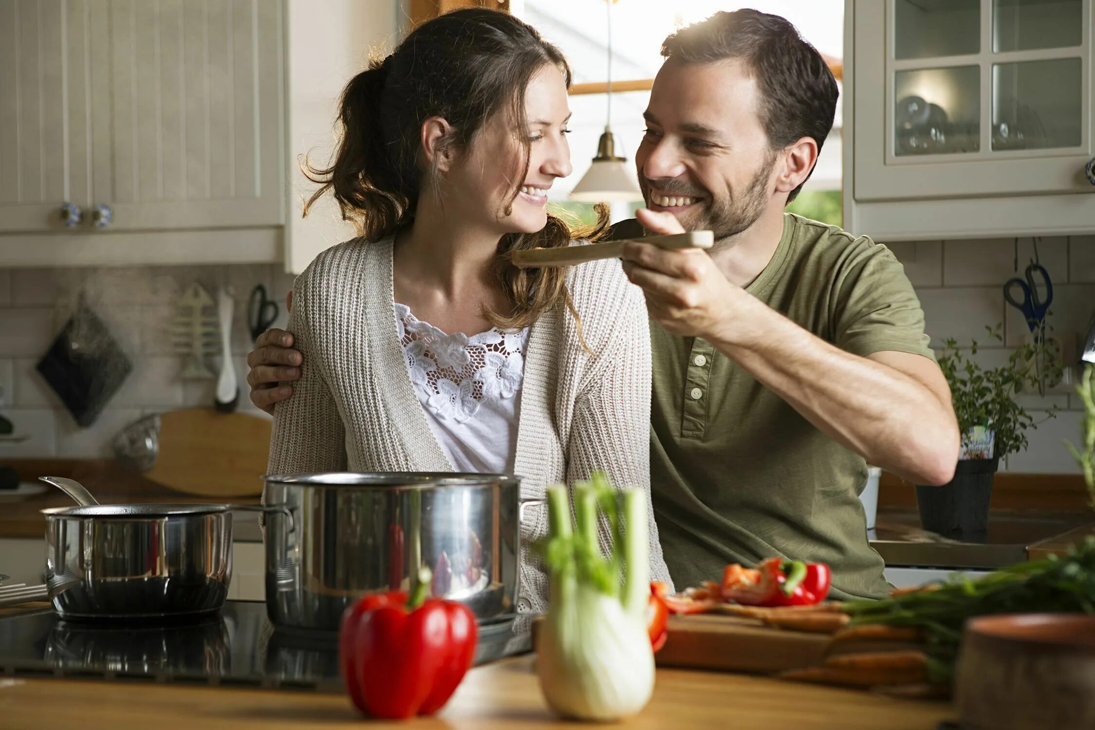 Дает мужу на кухне. Готовка на кухне. Готовим вместе. Муж и жена готовят. Семейная пара на кухне.