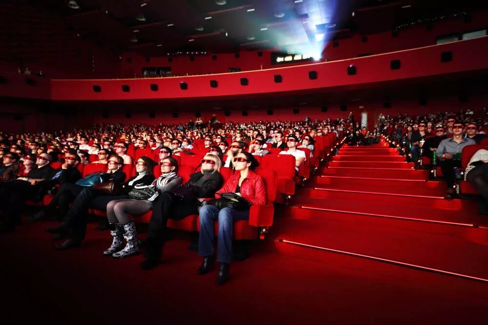 Премьера кинофильмов. Зал кинотеатра с людьми. Кинотеатр полный зал. Зрители в кинотеатре. Люди в кинотеатре.