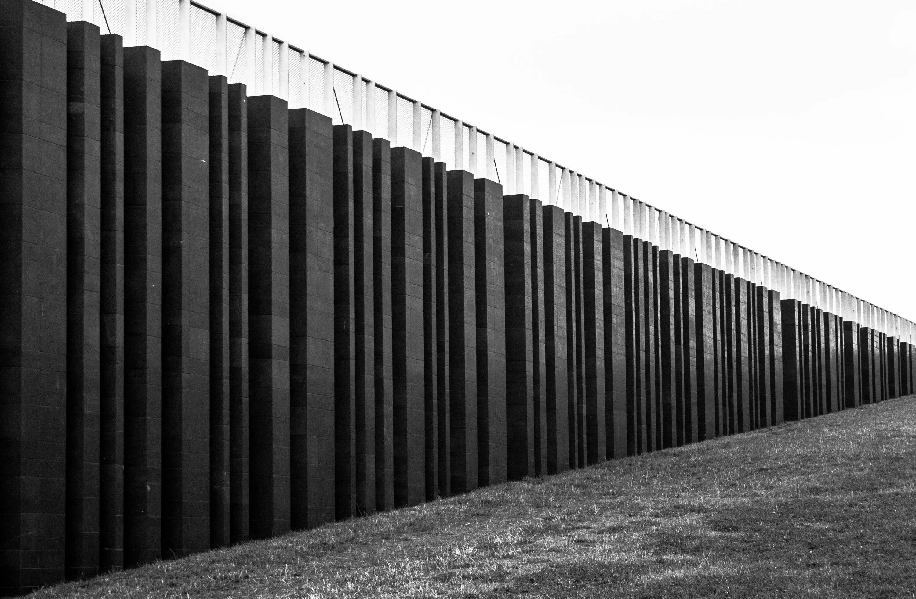 Стоит огромная стена. Забор рал 7024. Высокий забор. Высокий современный забор. Черный забор.