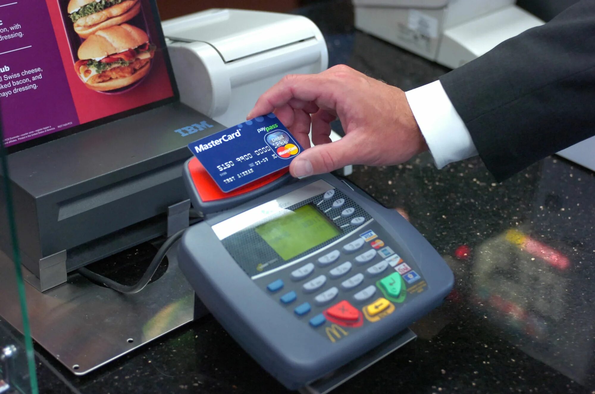 Как платить картой в магазине. POS терминал PAYPASS. Оплата картой в магазине. Оплачивает картой в магазине. Терминал оплаты в магазине.