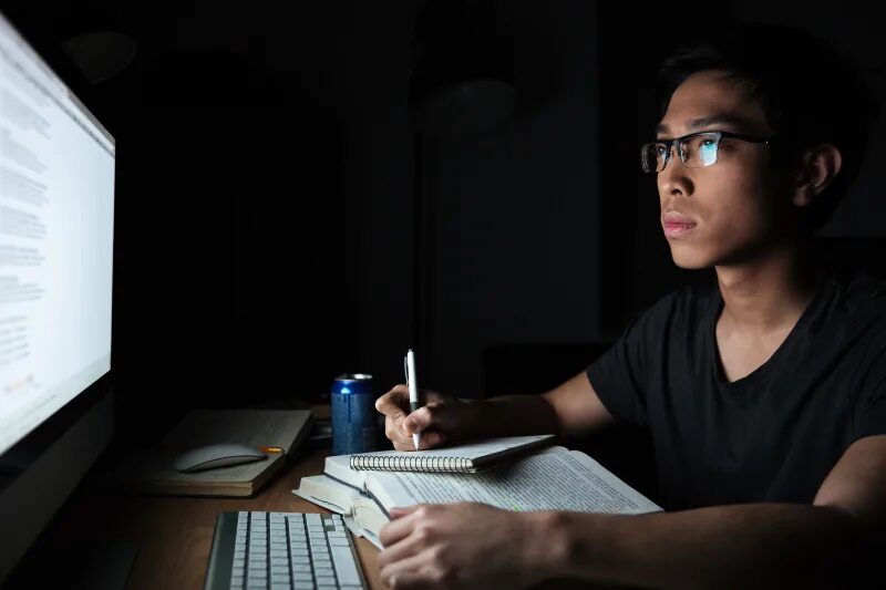 Write in the dark. Человек пишет код. asian man writes. vision therapy. detective glasses.