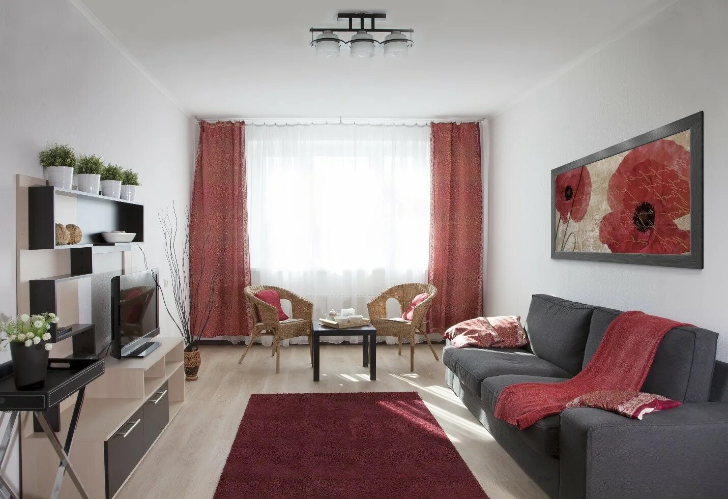 Квартира без телевизора. Гостиная с красным диваном. Гостиная комната. Интерьер прямоугольной гостиной. Расстановка мебели в гостиной.