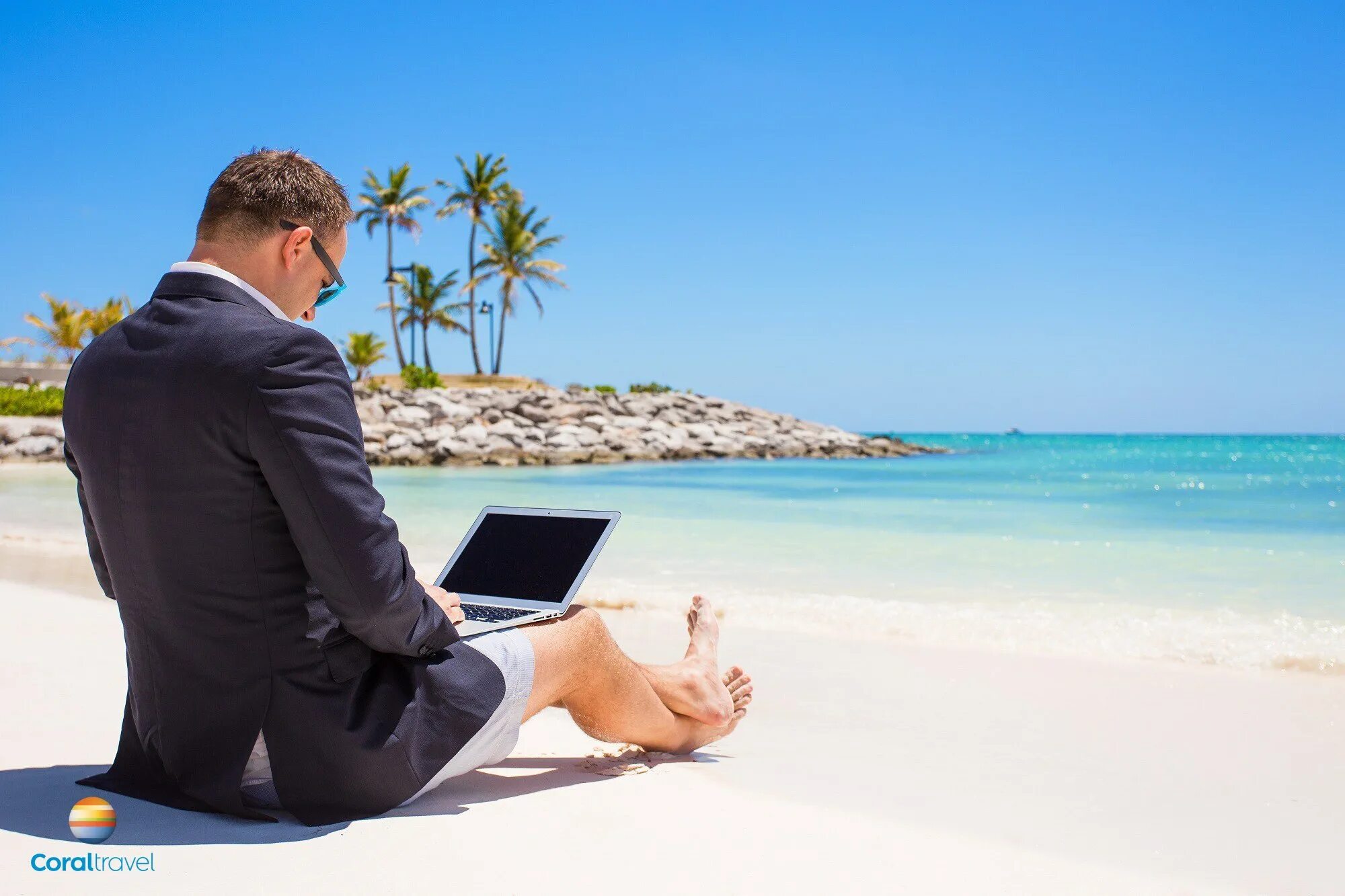 Бизнесмен на море. Отпуск. Мужчина на берегу моря с ноутбуком. В костюме на пляже.
