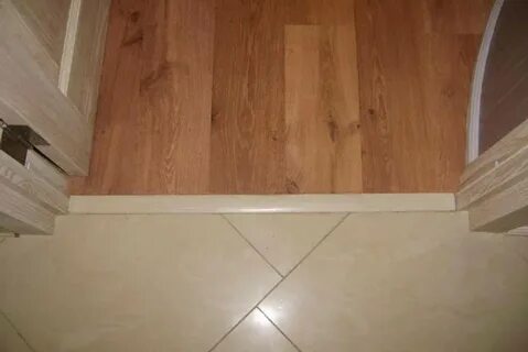Стык напольных покрытий под дверью