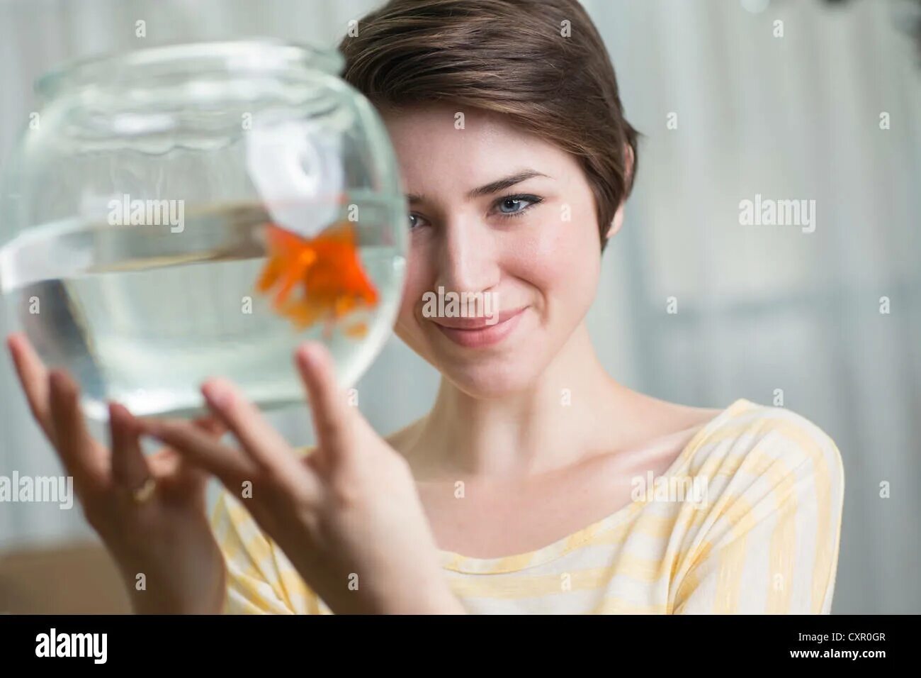 Концентрации внимания человека Goldfish. Beautiful Ladies holding Fish. Woman holding a Fish in mouth Beach.