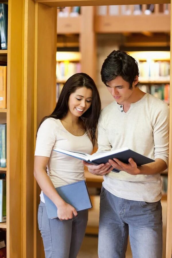Он смотрит в книгу. Смотрит в книгу. студент смотрит в книгу. студент смотрит в телефон. человек с книгой смотрит в камеру.