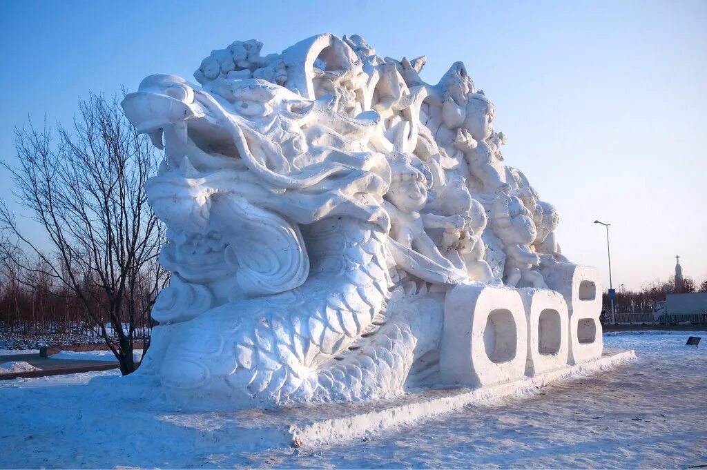 Снежная фигура дракон. Снежная скульптура дракона. Фигура дракона из снега. Снежные фигуры снежный дракон. Голова дракона на снегу