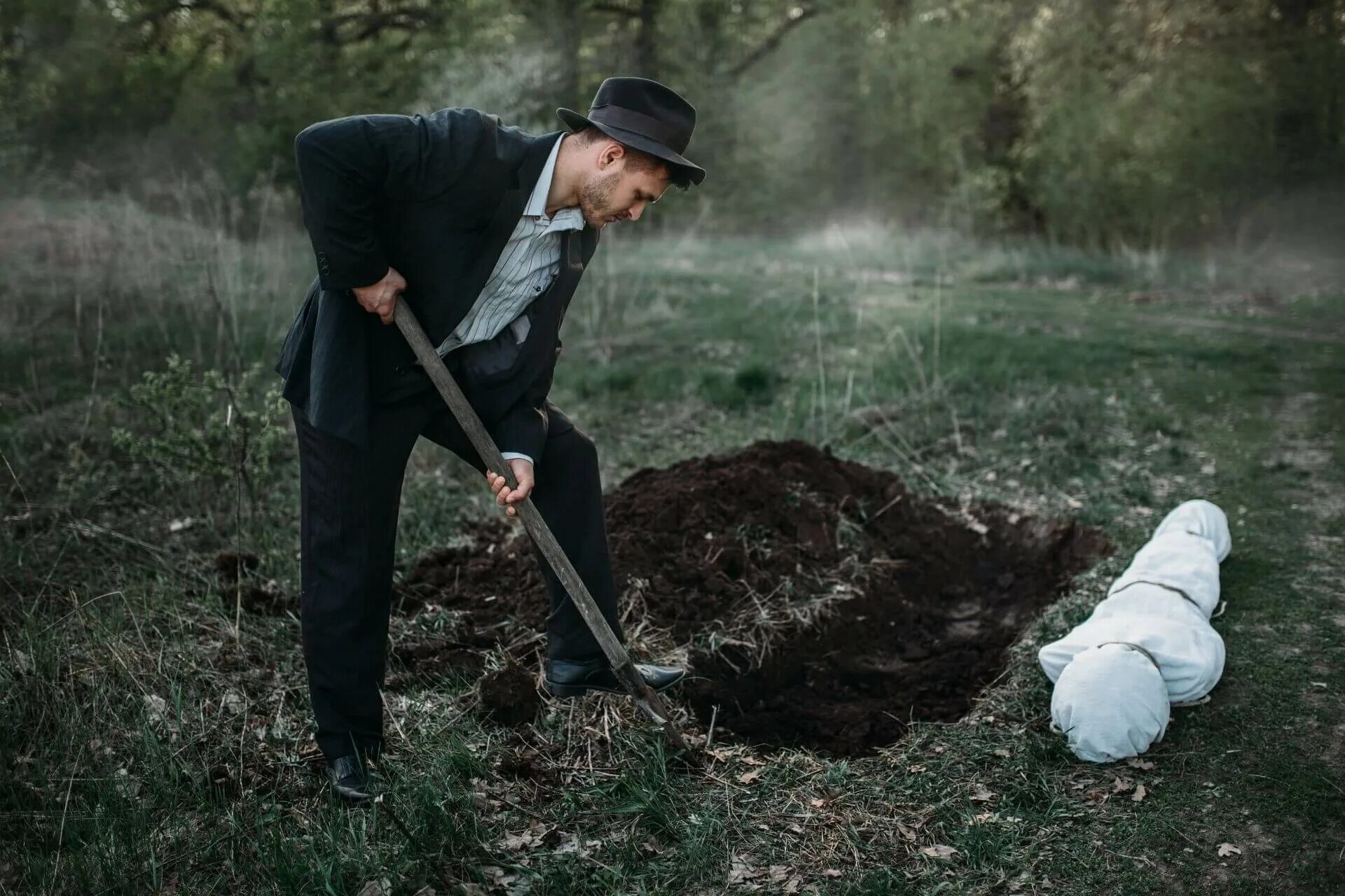 Человек копает яму. Кидает лопатой