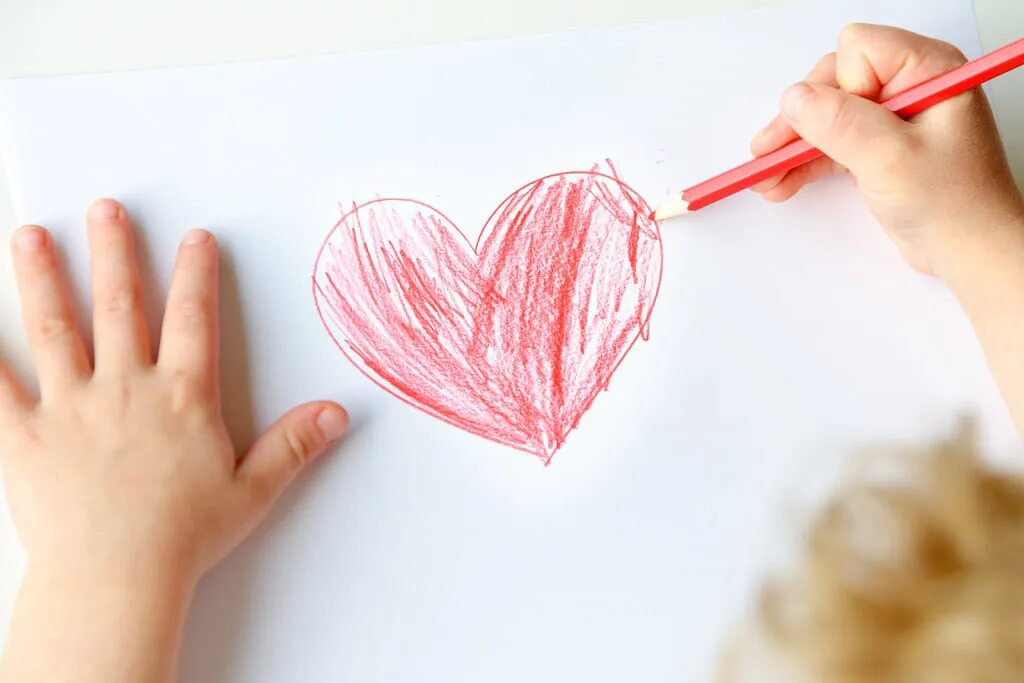 девочка держит сердце в руках. сердце на доске. дарю тебе сердце на листике. ребенок рисует сердце. сердечки нарисованные карандашом на бумаге.