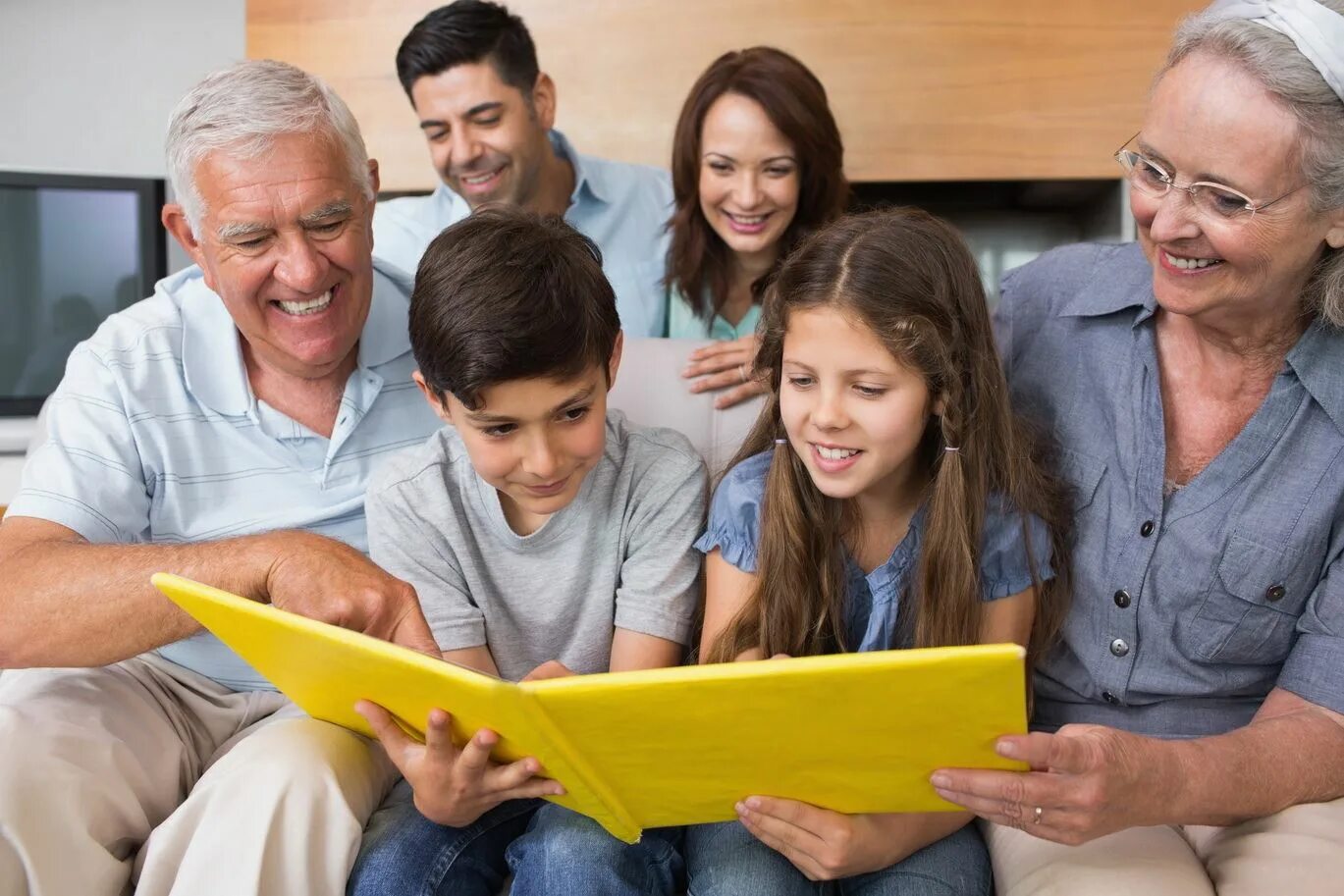 Семья листает фотоальбом. Семейный альбом. Фотоальбом дети с родителями. Семья смотрит фотоальбом. Рассматривая семейный альбом.