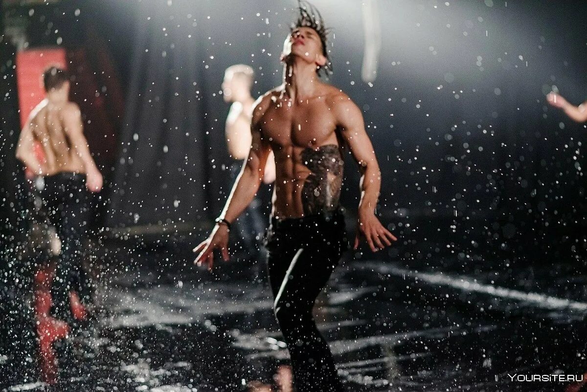 Танцы под дождем. Мужчина танцует. Шоу под дождем.