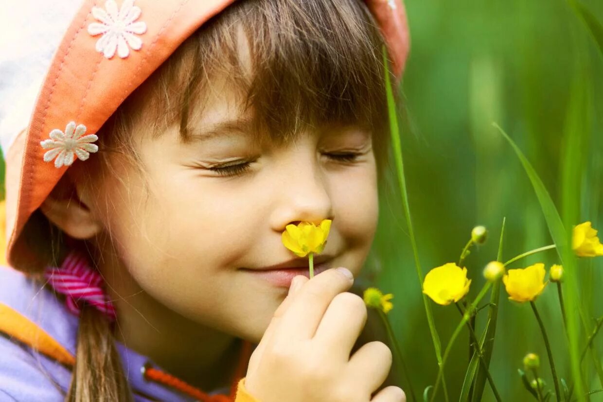 Ребенок нюхает цветок. Девочка нюхает цветок. Обоняние для детей. Человек нюхает цветок.