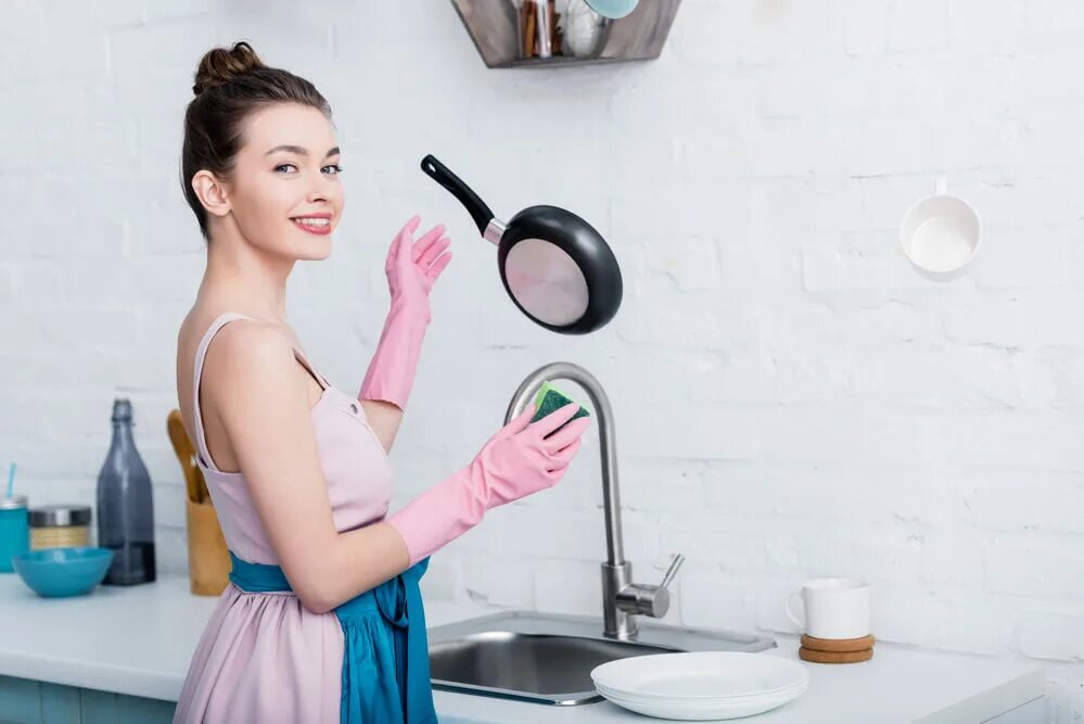 Мытье посуды. Улыбающаяся домохозяйка. Женщина моет посуду. Женщина моющая посуду.