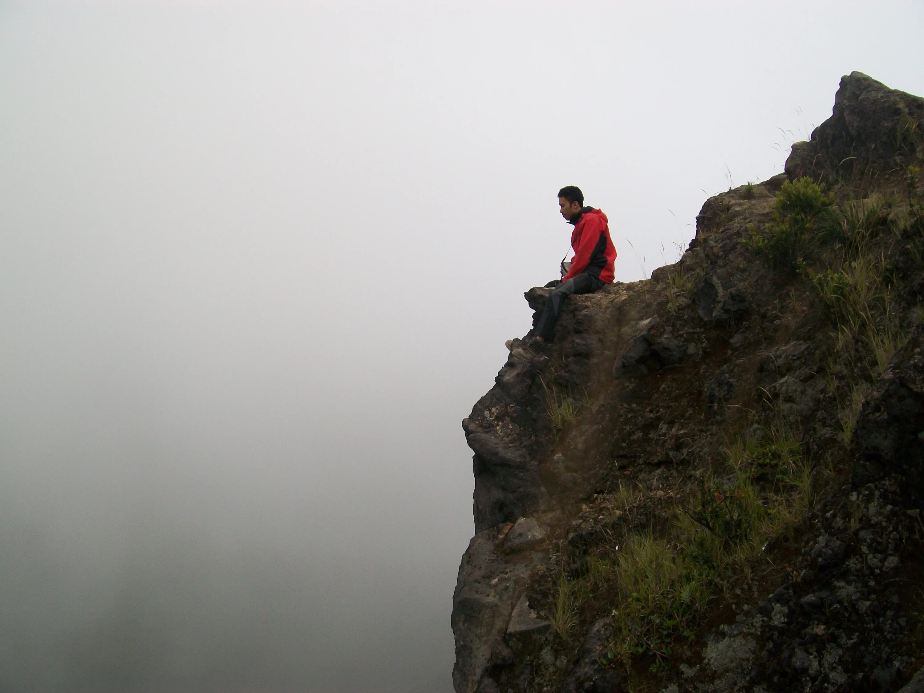 The cliff 4. Человек на обрыве. Парень сидит на скале. Человек сидит на обрыве. Человек на скалах.