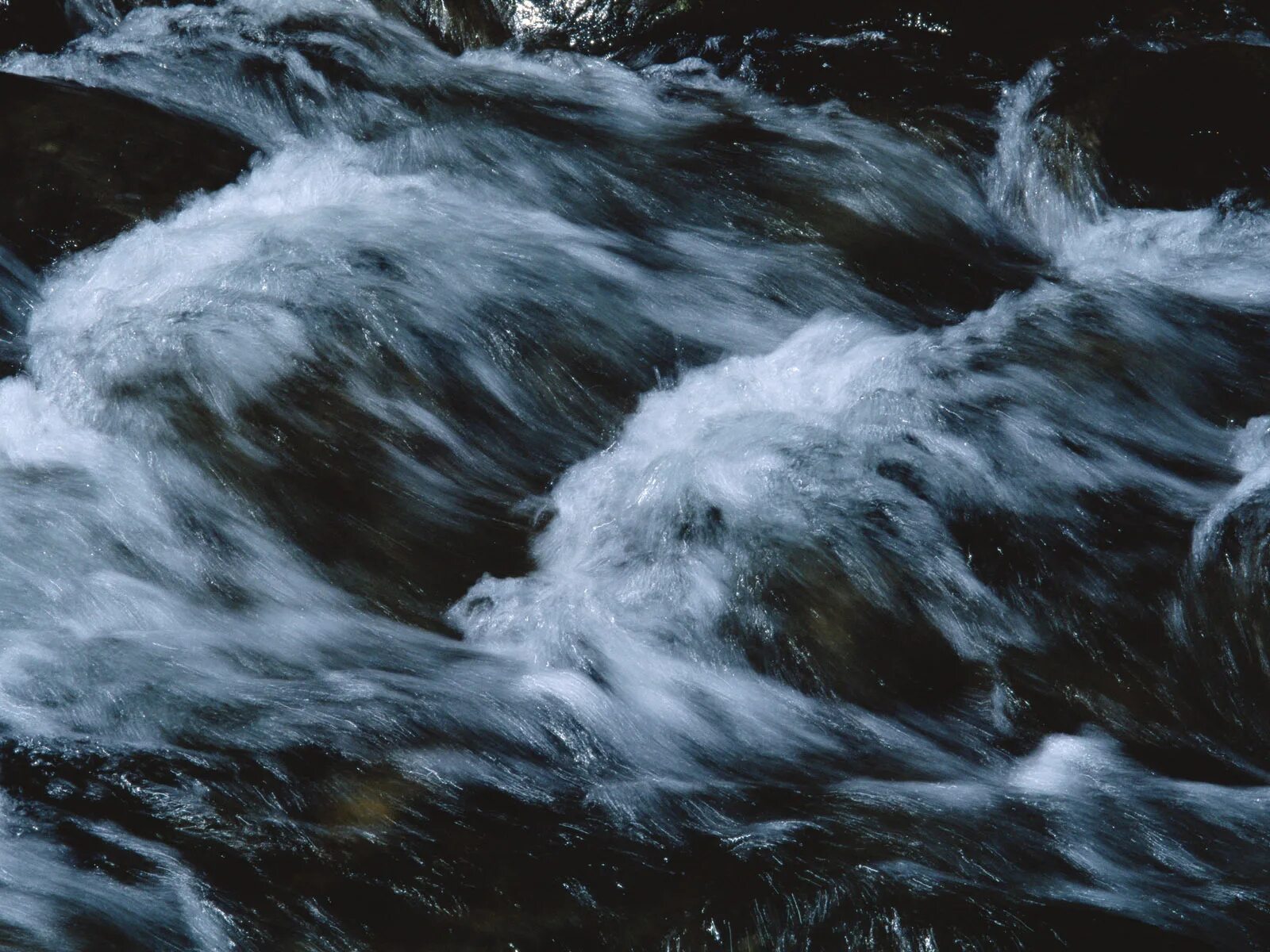 Потоки воды неслись. Сильное течение. Бурлящая река. Поток воды. Течение воды.