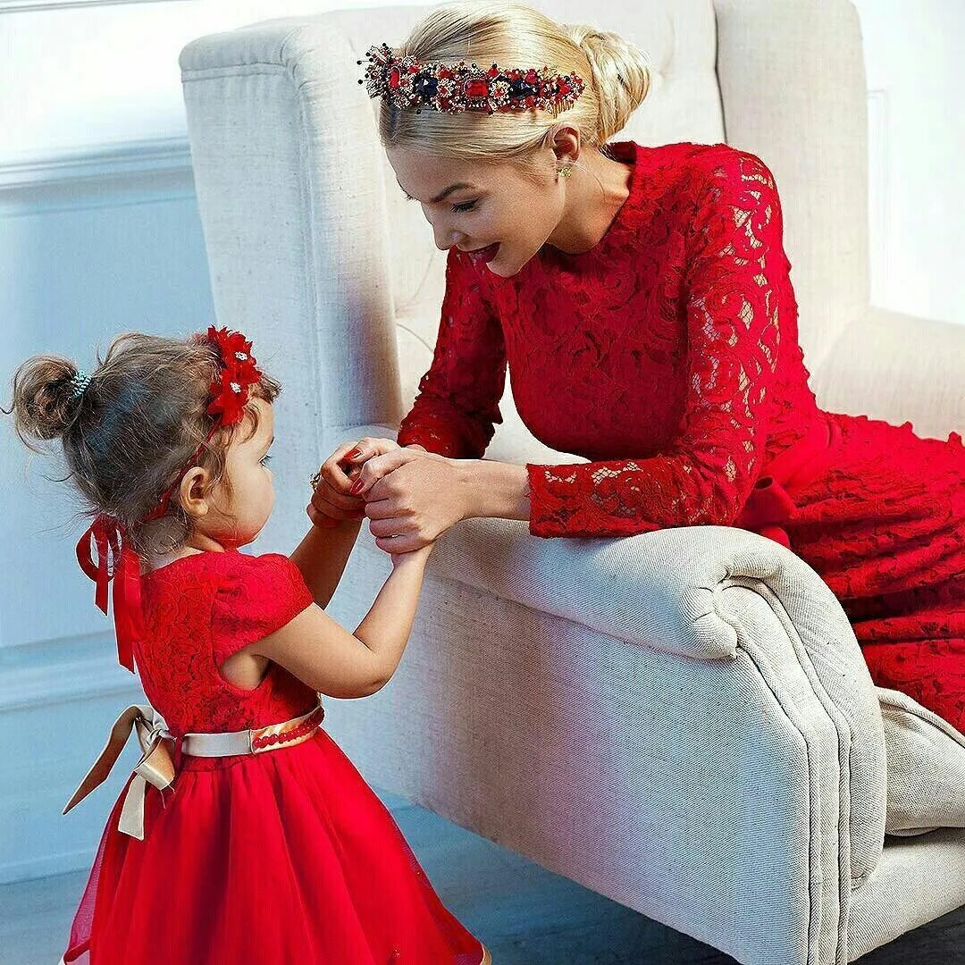 Мама наряжает дочь. Мама переодевает ребенка. Платья для мамы и дочки в одном стиле. Мать одевает ребенка. Мама одевает дочку.