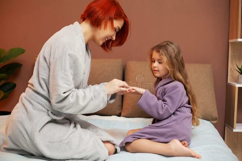 Мама делает массаж дочери. Отец массажирует дочь. Дочь массирует маме ноги. Массаж дочке.