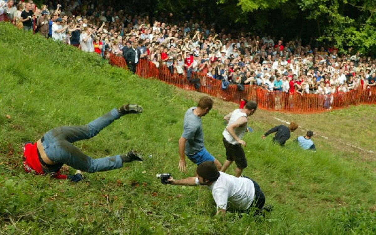 Спустился с холма. Cooper's Hill Cheese-Rolling and Wake. Куперсхилдская сырная гонка. Бегущий человек с холма. Катание сыра с горы в Англии.