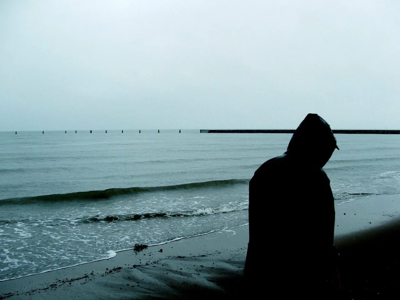 Грустью море не вычерпаешь. Одинокий парень у моря. Одинокий человек у моря. В капюшоне у моря. Человек в капюшоне у моря.