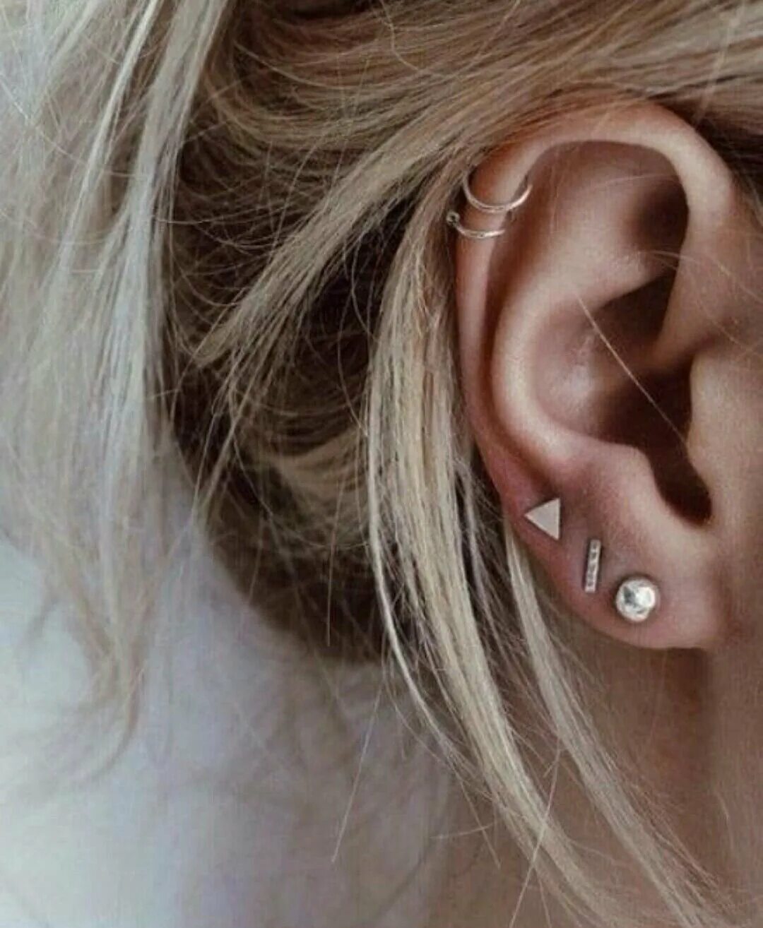 Белла торн пирсинг ушей. Прокол хряща (хеликс, флэт). Правое ухо прокалывают девушки. Пирсинг трагус поперечный. Красивый пирсинг.