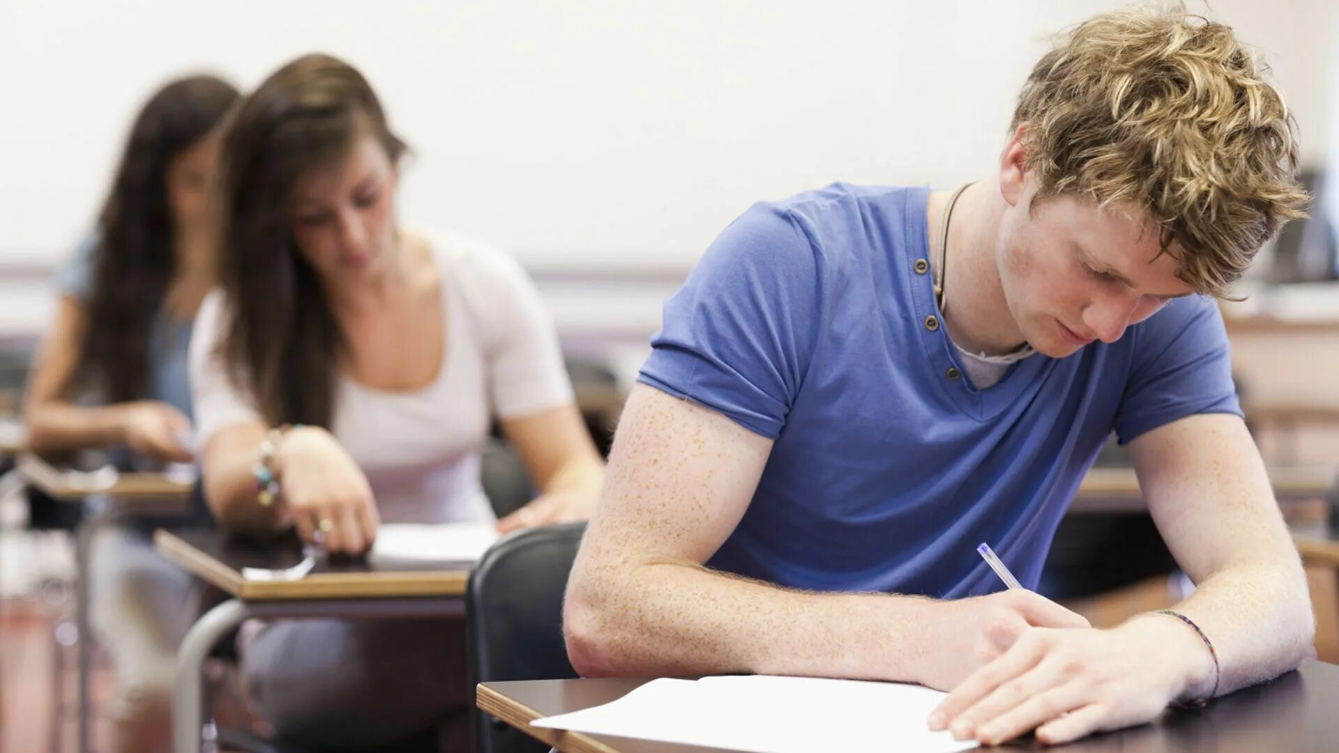 Examination student. Студент за партой. Взрослые за партой. Студент на экзамене. Подросток на экзамене.