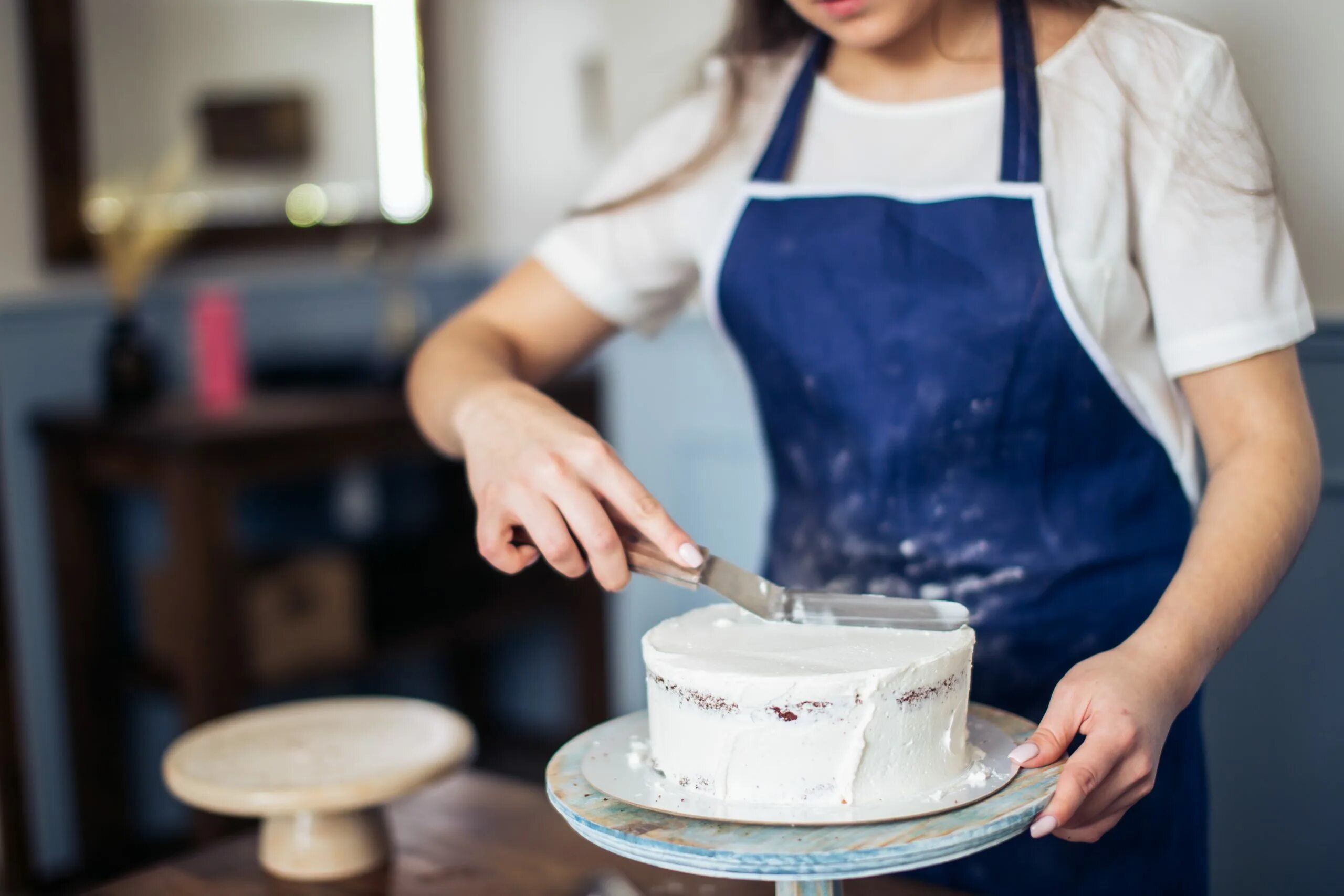 Девушка печет торт. Человек с готовкой торта. Кондитер печет торт. Кондитер с тортом в руках.