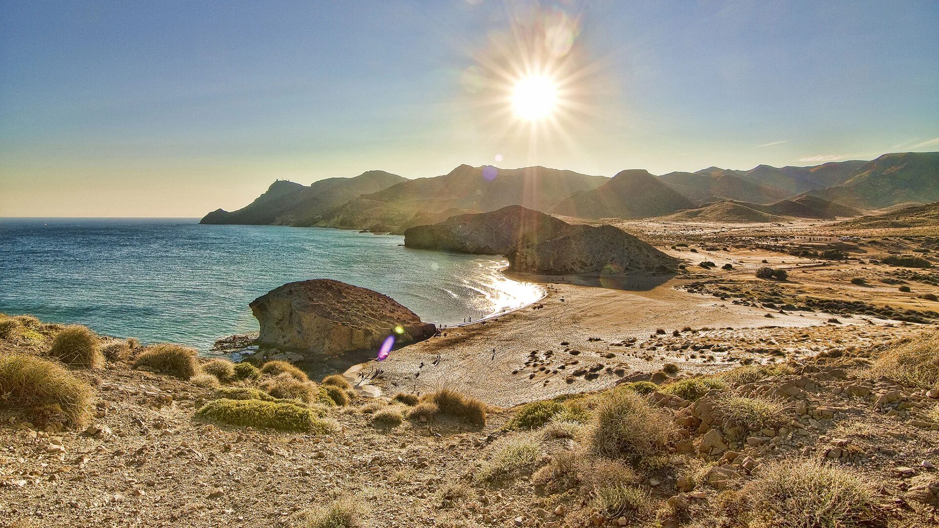 Светлый пляж и горы. Палящее солнце на пляже. Фото Испания природа солнце. Пляжи с горами без растительности. Coast like
