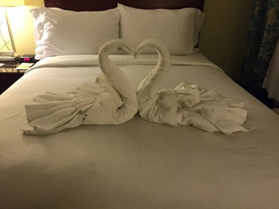 Фигуры из полотенец. Лебеди из полотенец в отеле. Полотенца на кровати в гостинице. Украшения из полотенец на кровати. Сложена кровать