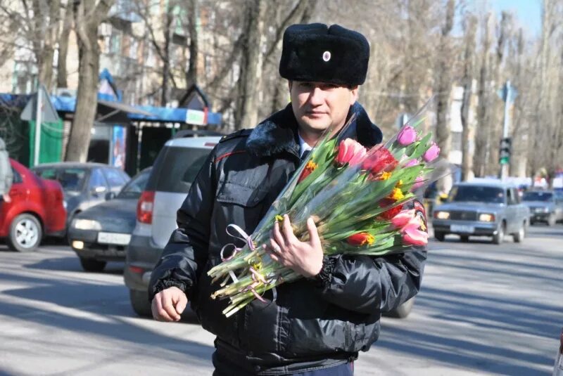 Мужчины на улице поздравляют женщин. Гибдд дарит цветы