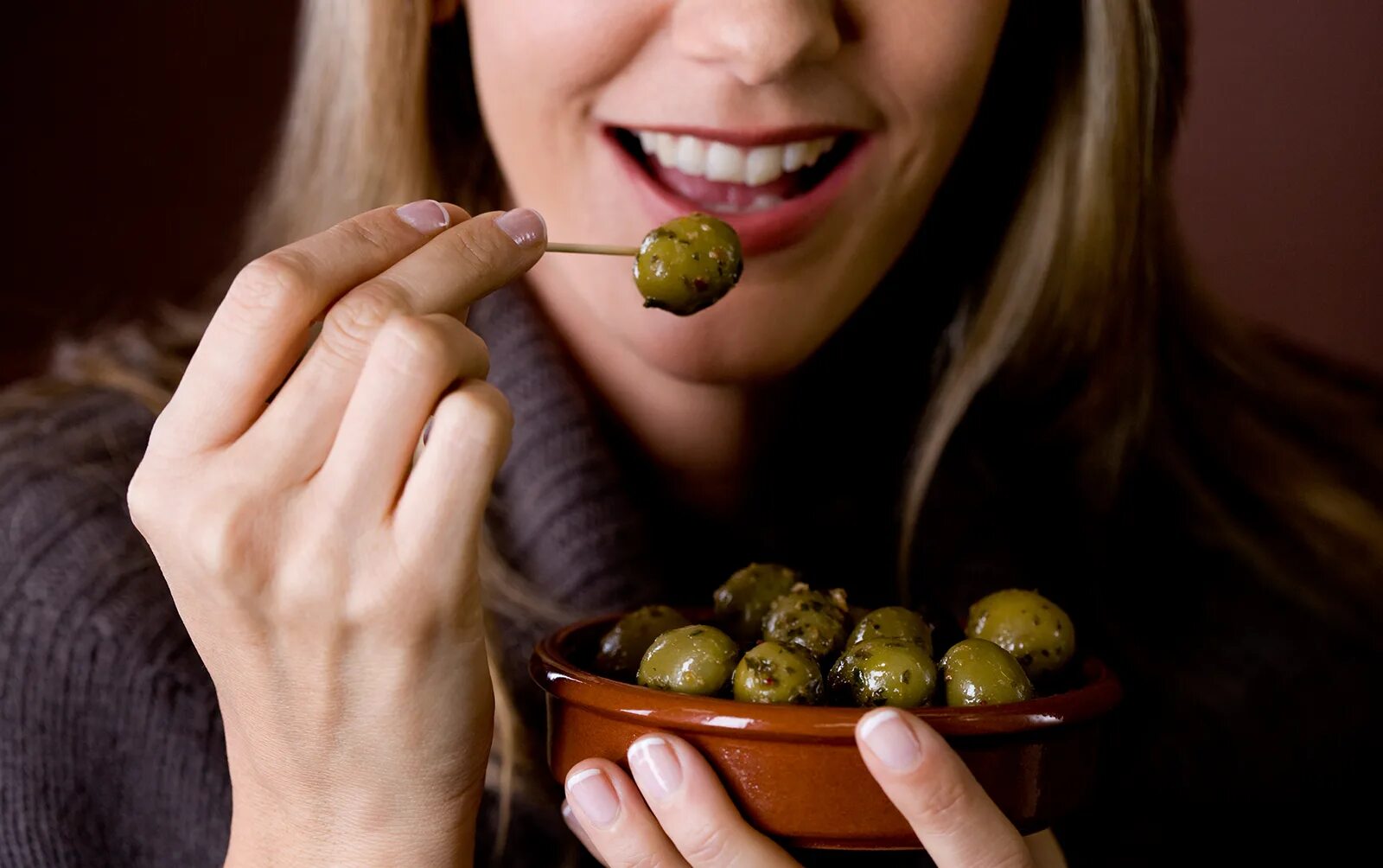 Польза косточек маслин. Оливки. Девушка с оливками. Девушка ест оливки. Человек ест маслины.