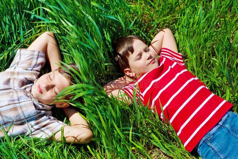 Мальчик на траве. Мальчик лежит на траве. Мальчик валяется на траве. Два мальчика лежат на траве.