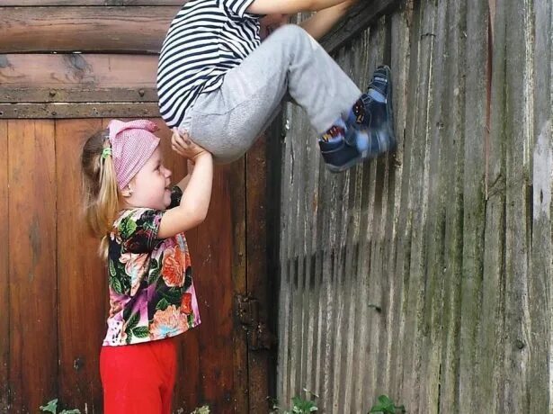 Мальчишки на даче. Ребенок перелазит через забор. Девочка лезет на забор. Мальчишки на заборе. Ребенок перелезает через.