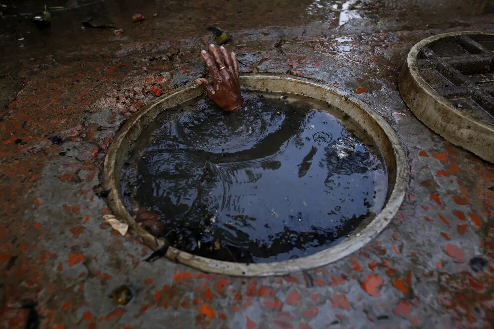 страшная канализация. сантехник канализация. чистка канализационных колодцев. чистильщик канализации в индии. открытый люк канализации.