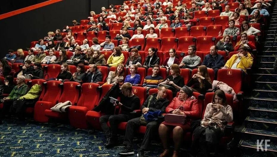 Люди в кинотеатре. Сидят в кинотеатре. Первый ряд в кинотеатре. Люди сидят в кинозале. В первом ряду