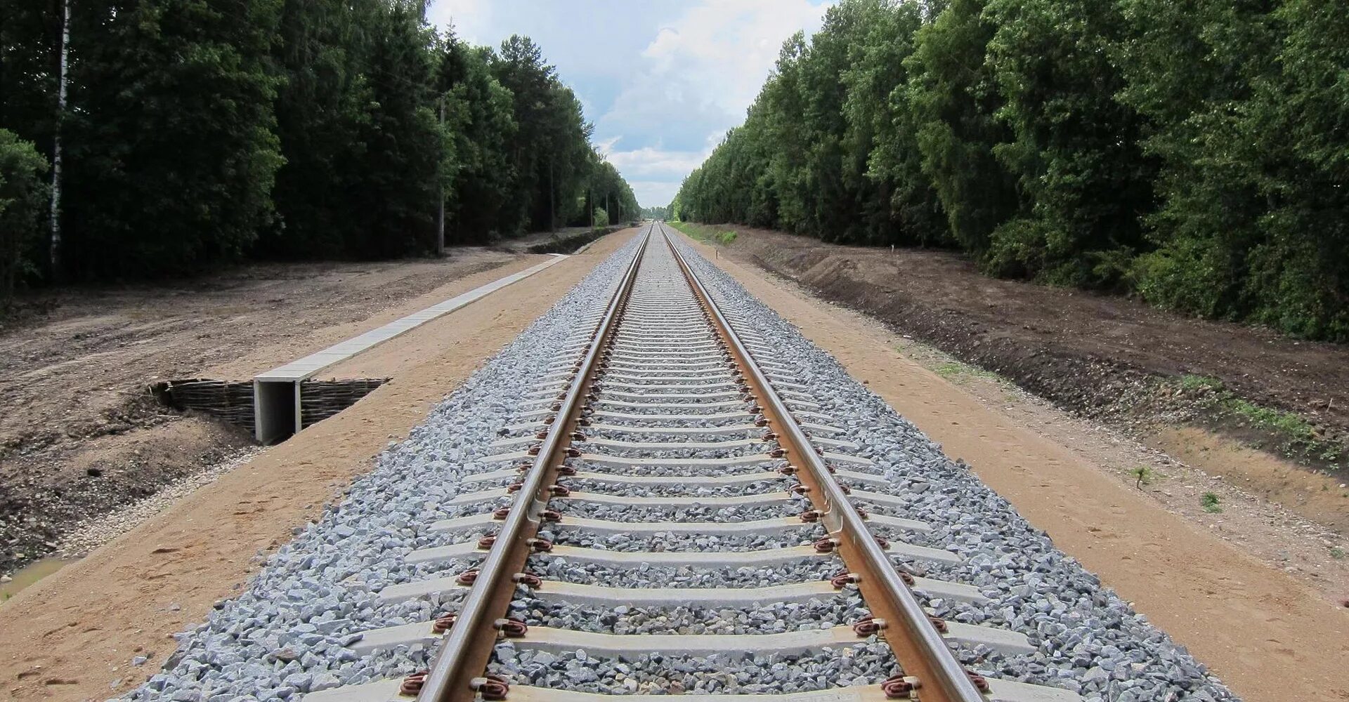 Насыпь земляного полотна железной дороги. Рельсошпальная решетка железнодорожного пути. Балластный слой железнодорожного пути. Железнодорожное полотно.