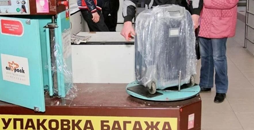Упаковка чемодана в пленку. Упаковка багажа в стрейч пленку. Упаковка чемодана в аэропорту. Чемодан в стрейч пленке. Упаковка чемодана в пленку.