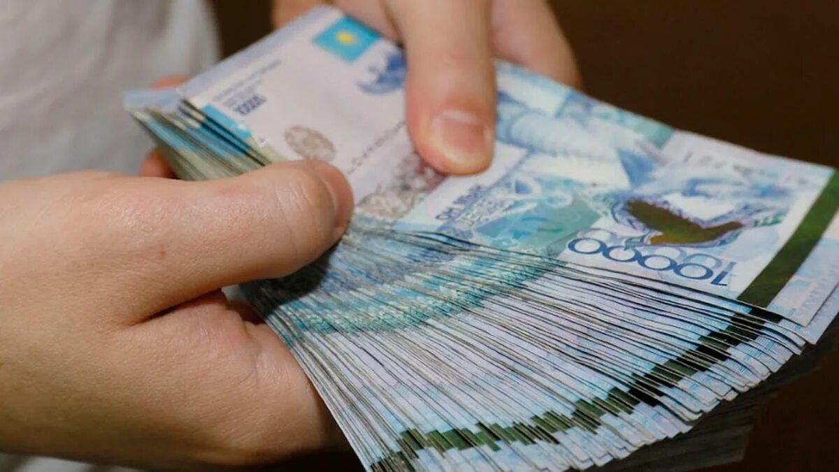 Получить деньги в тг. Деньги тенге. пачка казахстанских денег в руке. тенге в руках. деньги в руках.