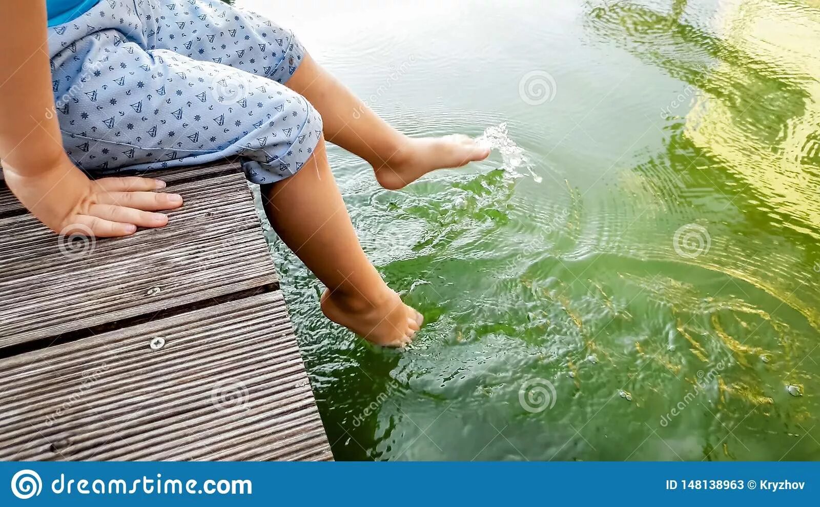 Ноги держать холодной воде. Девочка плескается в воде ногами. Ноги плещут в воде. Ноги в воде дерево. Маленькая девочка плескает ногами в воде.