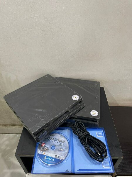 Ps4 slim avec une manette et un CD